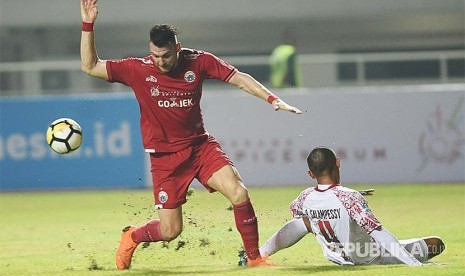 Striker Persija Jakarta Marko Simic (kiri) mencoba melewati hadangan pesepak bola Persipura Jayapura Ricardo Salampessy (kanan) dalam laga lanjutan Liga 1 di Stadion Pakansari, Bogor, Jumat (25/5).