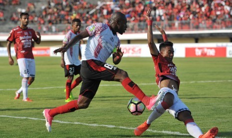 Striker Persipura Boaz Solossa (kiri) berebut bola dengan bek Bali United, Andhika Pradana Wijaya dalam pertandingan Liga 1 di Stadion I Wayan Dipta, Gianyar, Bali, Ahad (23/4).