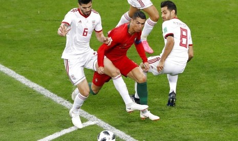 Striker Portugal, Cristiano Ronaldo (tengah) dijepit dua pemain Iran pada laga penyisihan Piala Dunia 2018, Mordovia Arena di Saransk, Rusia, Selasa (26/6) dini hari WIB. Laga berakhir imbang 1-1.