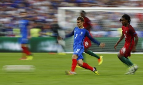 Striker Prancis Antoine Griezmann sedang berusaha melepaskan diri dari kawalan pemain Portugal Renato Sanches