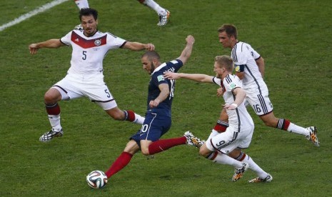 Striker Prancis, Karim Benzema (dua kiri), melepaskan tembakan di tengah kepungan pemain Jerman di laga perempat final Piala Dunia 2014 di Stadion Maracana, Rio de Janeiro, Jumat (4/7). 