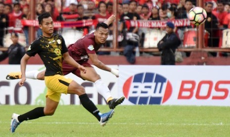 Striker PSM Makassar Ferdinan Sinaga (kanan) dihalangi pesepak bola PS Barito Putera Dandi Maulana (kiri) saat berusaha melepaskan tendangan pada pertandingan Liga 1 di Stadion Andi Mattalatta, Makassar, Sulawesi Selatan, Selasa (18/7). 