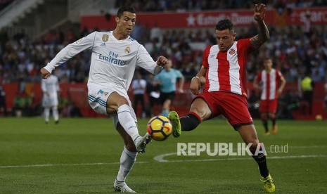 Striker Real Madrid Cristiano Ronaldo berebut bola dengan pemain Girona Aday Benitez pada pertandingan  Laliga di Montilivi stadium in Girona, Spanyol.