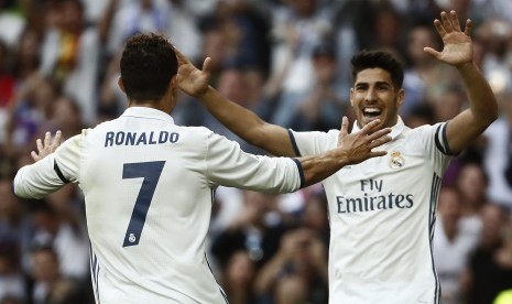 Striker Real Madrid, Cristiano ROnaldo (kiri) merayakan gol bersama Marco Asensio pada laga La Liga lawan Sevilla di Santiago Bernabeu, Ahad (14/5). Madrid menang 4-1.