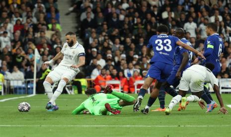 Striker Real Madrid Karim Benzema (kiri) menceploskan bola ke gawang Chelsea pada leg pertama perempat final Liga Champions 2022/2023, Kamis (13/4/2023). 