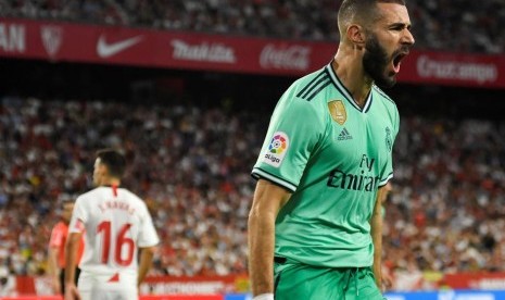 Striker Real Madrid, Karim Benzema merayakan gol ke gawang Sevilla pada laga La Liga di Stadion Ramon Sanchez Pizjuan, Senin (23/9) dini hari WIB. 