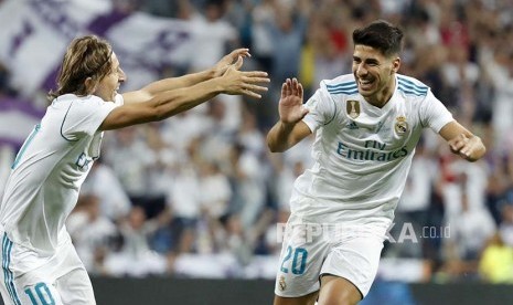 Striker Real Madrid Marco Asensio (kanan) merayakan golnya dengan rekan setimnya Luka Modric pada pertandingan leg ke-2 Piala Super Spanyol antara Real Madrid vs Barcelona FC di Stadion Santiago Bernabeu, Madrid, Spanyol, Kamis (17/8) pagi.