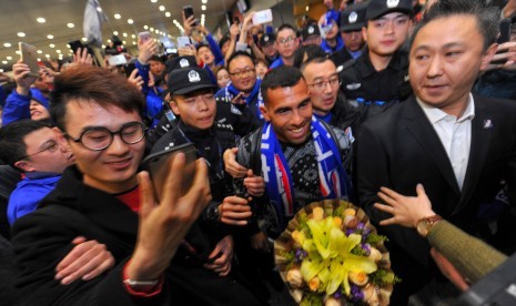 Striker Shanghai Shenhua, Carlos Tevez (tengah) berjalan menembus kerumuman fan yang menyambut kedatangannya di Bandara Internasional Shanghai, Kamis (19/1). Tevez baru dibeli Shenhua dan Boca Juniors.