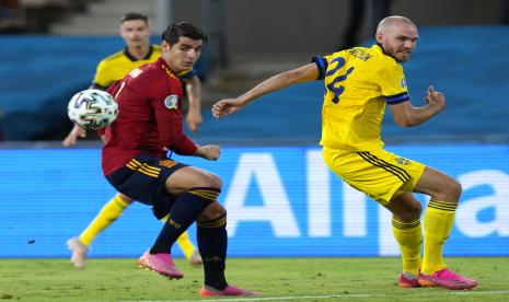 Striker Spanyol Alvaro Morata (kiri) berduel dengan penggawa Swedia Marcus Danielson saat kedua tim bentrok pada laga Grup E Piala Eropa 2020 di Seville, Spanyol, Selasa (15/6).