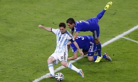 Striker Timnas Argentina, Lionel Messi (kiri), melepaskan tembakan menjebol gawang Bosnia-Herzegovina dalam laga Grup F Piala Dunia 2014 di Stadion Maracana, Rio de Janeiro, Ahad (15/6). 