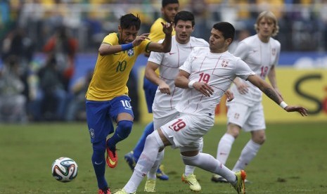 Striker Timnas Brasil, Neymar (kiri), berebut bola dengan pemain Serbia, Aleksandar Mitrovic, dalam laga uji coba di Stadion Morumbi, Sao Paulo, Jumat (6/6). 