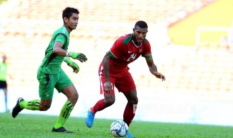 Striker timnas  Indonesia Marinus Wanewar dihadang kiper Kamboja dalam pertandingan Grup B melawan Kamboja di Selangor, Malaysia, Kamis (24/8)