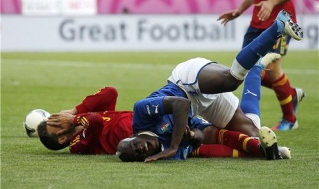 Striker timnas Italia (kanan), Mario Balotelli, terlibat adu fisik dengan bek Spanyol, Gerard Pique, di laga Grup C Piala Eropa 2012 di PGE Arena, Gdansk, Polandia, Ahad (10/6). 