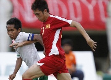 Striker Timnas U21 Indonesia, Andik Vermansyah (kiri), berebut bola dengan pemain Vietnam, Nguyen Thanh Long, di babak semifinal Piala Hassanal Bolkiah 2012 di Bandar Seri Begawan pada Rabu (7/3).