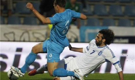 Striker timnas Yunani, Georgios Samaras (kanan), berebut bola dengan pemain Slovenia, Dejan Kelhar, dalam laga uji coba di Kufstein pada 26 Mei lalu. 