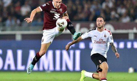 Striker Torino Andrea Belotti (kiri) dijaga pemain AC Milan Davide Calabria.