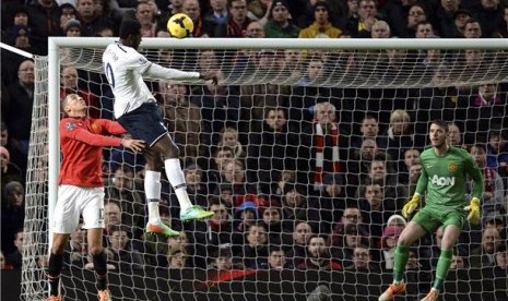 Striker Tottenham Hotspur, Emmanuel Adebayor (tengah), melepaskan sundulan menjebol gawang Manchester United dalam laga Liga Primer Inggris di Old Trafford, Manchester, Rabu (1/1).