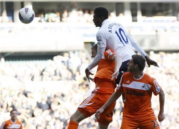 Striker Tottenham Hotspur, Emmanuel Adebayor (tengah), melepaskan sundulan saat membobol gawang Swansea City di laga Liga Primer Inggris di Stadion White Hart Lane, London, Ahad (1/4). 