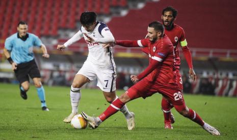 Striker Tottenham Hotspur Heung-Min Son (kiri) diadang oleh pemain Royal Antwerp Jeremy Gelin (kanan) ketika kedua tim bentrok pada lanjuta Grup J Liga Europa, Jumat (30/10).