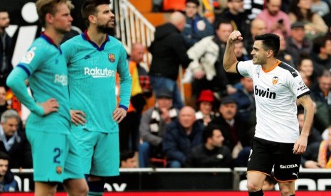 Striker Valencia, Maximiliano Gomez (kanan) merayakan gol ke gawang Barcelona pada laga La Liga di Mestalla, Sabtu (25/1). Valencia menang 2-0.