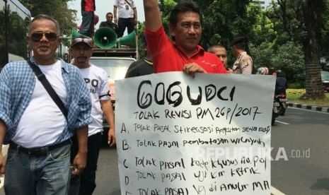 Suasana demo sopir taksi daring di depan Kementerian Perhubungan, Rabu (25/10) menolak lima poin mengenai stiker mobil, pembatasan wilayah, kode khusus pelat nomor, uji KIR ketrik, dan pasal yang dianulir Mahkamah Agung (MA). 