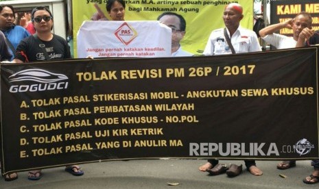 Suasana demo sopir taksi daring di depan Kementerian Perhubungan, Rabu (25/10) menolak lima poin mengenai stiker mobil, pembatasan wilayah, kode khusus pelat nomor, uji KIR ketrik, dan pasal yang dianulir Mahkamah Agung (MA). 