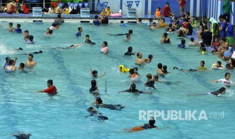 Suasana keramaian pengunjung saat berenang di kolam renang Karang Setra, Jalan Sirnagalih, Kota Bandung, Selasa (27/6). Berwisata air masih menjadi tempat liburan favorit bagi pengunjung dari dalam kota maupun luar kota untuk mengisi liburan seusai lebaran.