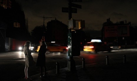  Suasana lalu lintas di salah satu sudut kota yang gelap akibat terputusnya aliran listrik di New York, Rabu (31/10).      (Tina Fineberg/AP)