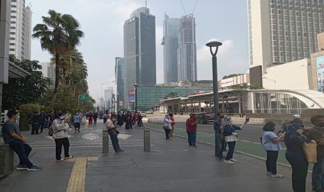 Suasana masyarakat saat menunggu parade MotoGP di Bunderan HI, Jakarta.