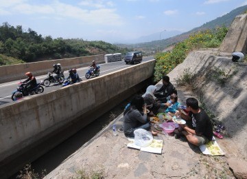 Suasana pemandangan perbukitan di Jalan Lingkar Nagreg, dinikmati sejumlah pemudik dengan beristirahat sambil mengkonsumsi perbekalan mereka. (Republika/Aditya)