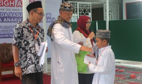 Suasana pemberian santunan kepada anak yatim dan dhuafa oleh pengurus Mushala Al Hidayah.