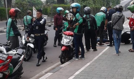 Suasana saat Warsilah yang terjatuh usai dijambret dibawa ke sisi jalan untuk dilakukan pertolongan, Senin (2/7).