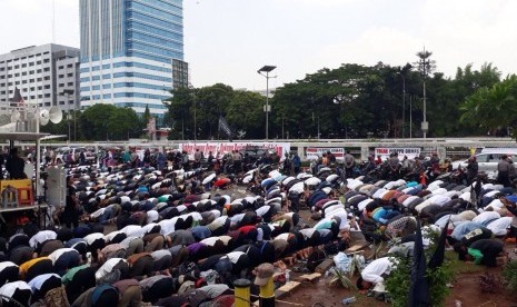 Suasana shalat zuhur berjamaah massa aksi tolak Perppu Ormas di depan Gedung DPR RI, Selasa (24/10).