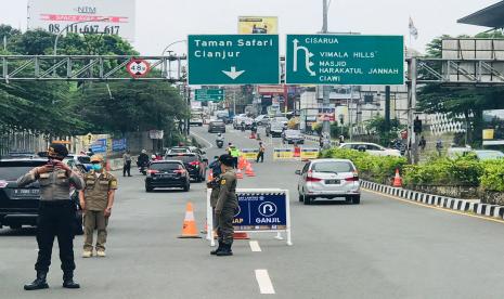 Suasana uji coba ganjil-genap kendaraan bermotor kawasan Puncak, tepatnya di Simpang Gadog, Ciawi, Kabupaten Bogor, Ahad (12/9). 