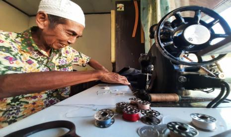 Sujono tersenyum menerima bantuan mesin jahit  dari BMH.