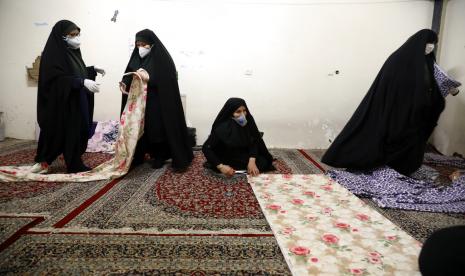 Ahli Medis Sarankan Iran Tak Buka Masjid. FOto: Sukarelawan mengenakan masker membantu menjahit seprei untuk kasur rumah sakit. Para wanita relawan bekerja dari masjid di Teheran, Iran, Ahad (5/4). Iran sedang melawan Covid-19 yang cukup memukul negara tersebut. 