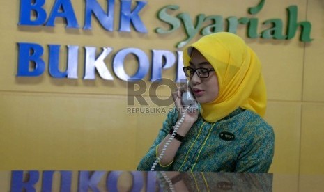 Sumber Dana Murah Bank Syariah: Teller berada di kantor Bank Syariah Bukopin, Jakarta, Rabu (8/4).