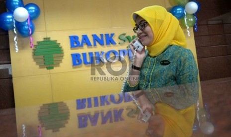 Sumber Dana Murah Bank Syariah: Teller berada di kantor Bank Syariah Bukopin, Jakarta, Rabu (8/4).