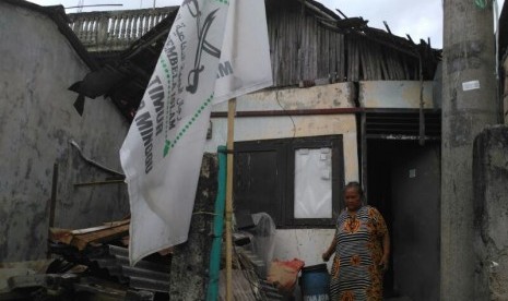 Sunarni (50) berdiri di depan rumahnya di Pejaten Timur, Jakarta Selatan, Senin (3/4) lalu. 