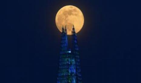 Allah tidak 'Bercanda' dalam Menciptakan Langit dan Bumi. Supermoon tampak sebagai latar gedung pencakar langit di London.