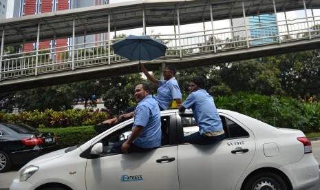 Sopir taksi melakukan aksi demo menolak keberadaan angkutan umum daring di Jalan Jenderal Sudirman, Jakarta, Selasa (22/3).