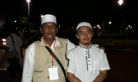 Suplir (kiri) bersama rekannya menjadi relawan pembagian air minum gratis bagi peserta Reuni 212 di Monas pada Sabtu (2/12) dini hari.