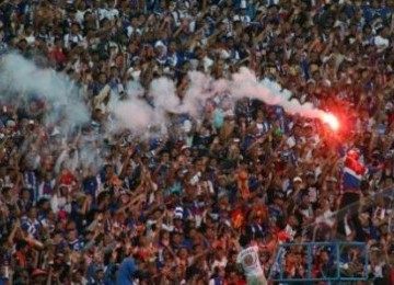 Suporter Arema Indonesia (Aremania) menyalakan kembang api usai mengetahui tim kesayangnnya berhasil menjadi runner up di akhir kompetisi ISL (Indonesia Super Liga) di Stadion Kanjuruhan, Malang, Ahad (19/6). 