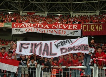 Suporter Indonesia memampangkan poster usai pertandingan semifinal sepakbola SEA Games ke-26 di Stadion Utama Gelora Bung Karno, Jakarta, Sabtu (19/11). (Republika Online/Fafa)