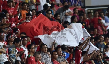 Suporter Indonesia membawa bendera merah putih ketika menyaksikan Timnas Indonesia melawan Filipina dalam pertandingan putaran I Sepak Bola SEA Games ke-28, di Stadion Jalan Besar, Singapura, Selasa (9/6).(Antara/Wahyu Putro)