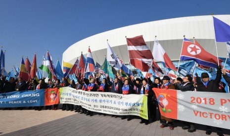 Suporter Korea Selatan pada Olimpiade Musim Dingin PyeongChang 2018 membawa bendera Korea Utara dan negara peserta lainnya. 