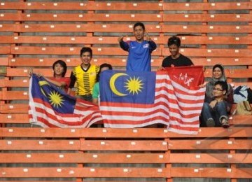 Suporter Malaysia memberikan semangat kepada tim negara mereka pada pertandingan babak penyisihan Grup A SEA Games XXVI antara Malaysia-Singapura di Stadion Utama Gelora Bung Karno Senayan, Jakarta, Senin (7/11).