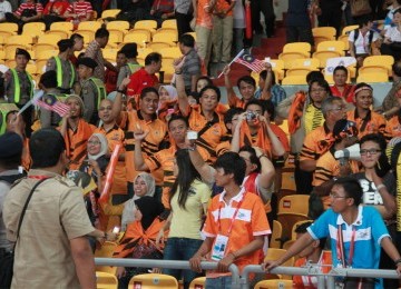 Suporter Malaysia menyambut gembira kemenangan timnya walau stadion didominasi oleh suporter Indonesia pada final sepak bola SEA Games 2011, GBK Jakarta,Senin, (21/11). (Republika Online/Fafa)