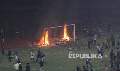 Suporter Persebaya membakar papan sponsor usai pertandingan Liga 1 2019 antara Persebaya dan PSS Sleman di Stadion Gelora Bung Tomo, Surabaya, Jawa Timur, Selasa (29/10). Kericuhan tersebut terjadi karena kekecewaan para suporter Persebaya usai timnya kalah 2-3 atas PSS Sleman. 