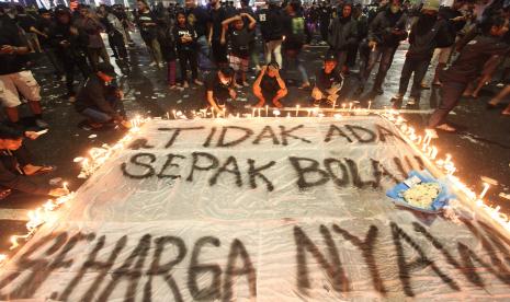 Suporter Persebaya menyalakan lilin saat mengikuti doa bersama di Tugu Pahlawan, Surabaya, Jawa Timur, Senin (3/10/2022). Doa bersama itu untuk para korban tragedi kerusuhan di Stadion Kanjuruhan, Malang. 